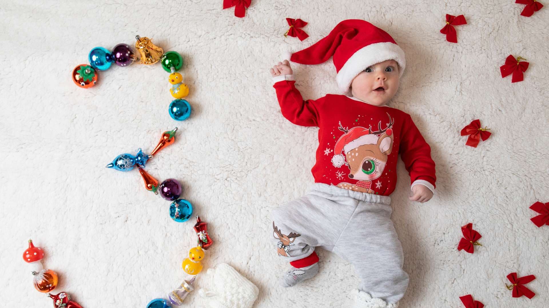 Бебе с коледна шапка на тематична бебешка фотосесия